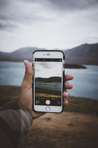 白天，手持金色iPhone 6的人在拍摄环岛湖的照片